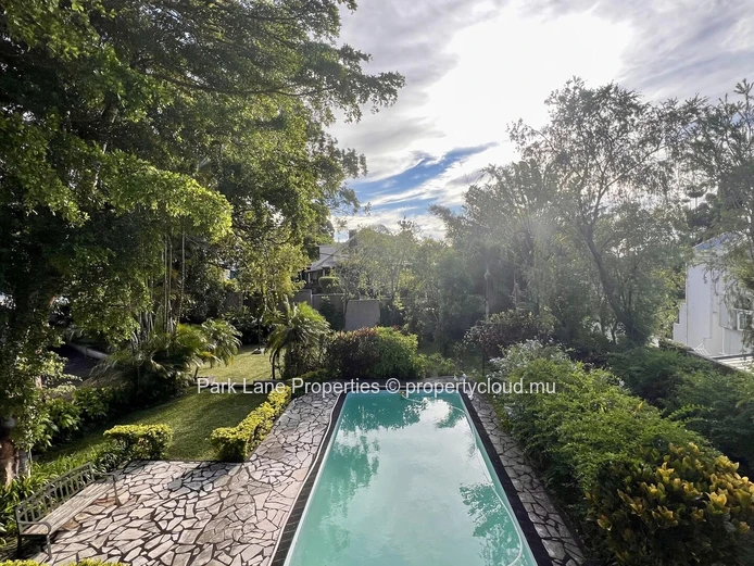 Maison à deux étages surplombant une magnifique piscine et des arbres matures à Floreal